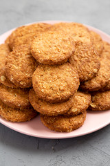 Cereal cookies on a pink plate on a gray surface, low angle view. Close-up.