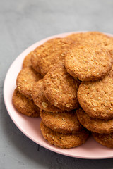 Cereal cookies on a pink plate on a gray surface, low angle view. Close-up.