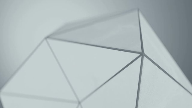 White polygonal shape with grunge surface. Abstract techno structure close-up. Seamless loop 3D render animation with shallow depth of field 4k UHD 3840x2160