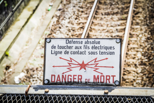Sign of danger of death by electric shock over the rails of the metro in Paris