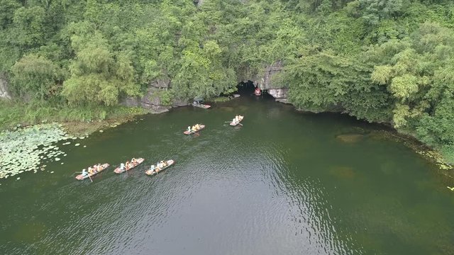 Stock footage 4k: Trang An rowboats cave tours with beautiful mountains view, Ninh Binh, Vietnam. Aerial view of Trang An - UNESCO World Heritage Site, one of the most popular destinations in Vietnam