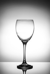 Transparent crystal wineglass on a light gradient background close-up
