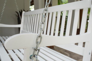 Fototapeta na wymiar The detail of white wood swing in the backyard.