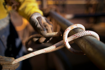Scaffolder using 10.5 MM static low stretch rope tie, fasten a clove hitch knot on a bight on...