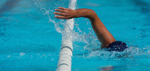 Swim competition swimmer athlete doing crawl stroke in swimming pool