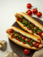 Pyszne domowe hot dogi. Parówka, bułka, szczypiorek, pomidor na białym tle. Widok z góry.