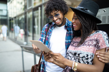 Young modern stylish couple using tablet in urban city