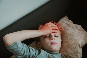 Sick child with headache, pain concept, virus or infection, kid with fever