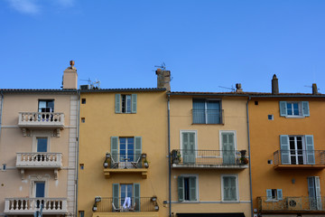 Colored house facade in the historic center of Saint Tropez, France, with balconies