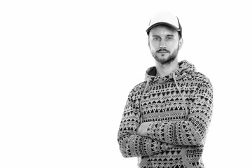 Studio shot of young man wearing hat with arms crossed