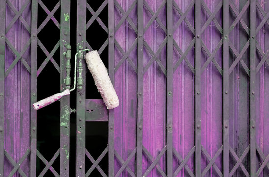 Paint Roller Hang On Old Shutter Door Background.