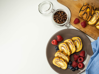 Ciasto rolada z kremem i owocami na białym tle. Widok z góry.