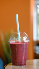 berry smoothie in a plastic cup.