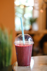 berry smoothie in a plastic cup.