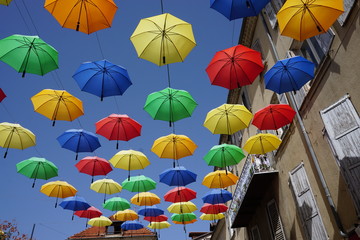 Fototapeta na wymiar colorful umbrellas hanging as decoration in a street in a town in France