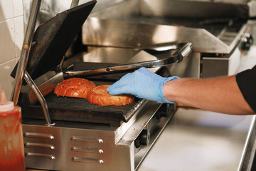 Cook prepares a hamburger.