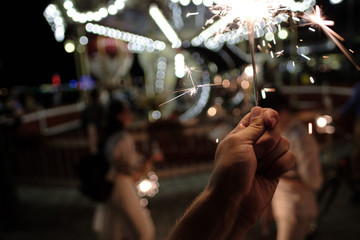 Hand with Sparkler. blurry sparks and background