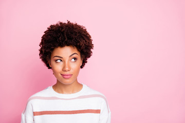 Photo of curious sly black skinned girl glancing at empty space wearing striped white sweater...