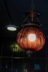 Fototapeta na wymiar Vintage orange light lamps retro design of ceiling hanging light bulb interior decoration