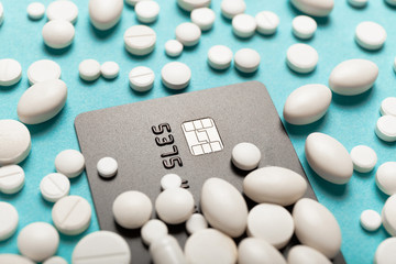 Credit card and medicines (pills). High cost of treatment in hospital, expensive medications concept.