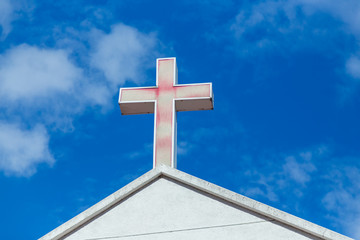 Faded cross on church roof