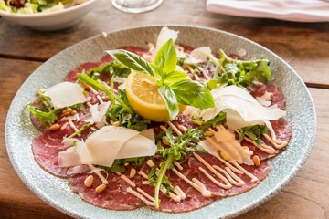 White dish with carpaccio of beef