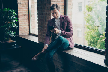 Photo of chic macho business guy looking telephone sitting on window sill search new workers online...