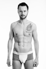 Studio shot of young shirtless man standing and wearing underwear