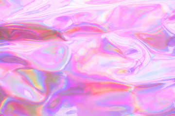 Holographic wrinkled abstract foil texture. Glittering blurred surface pack. Multicolor bright holographic foil background.
