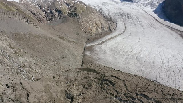 Aerial shot over the Gornergletscher glacier, camera tilting upward to reveal high altitude summits including the Liskam. Zermatt, Switzerland