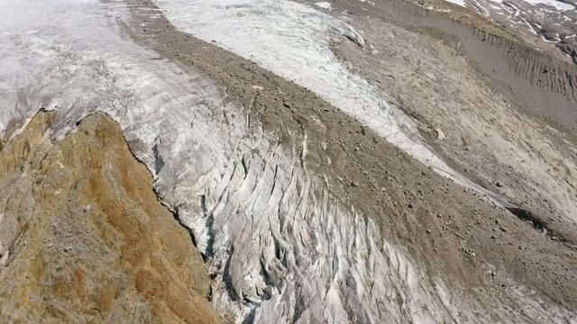 Aerial lateral moving shot over glacier crevasses and moraine in Zermatt, Switzerland