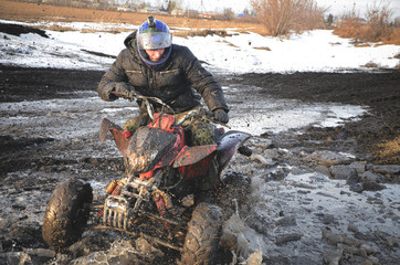 Naklejka premium Biker on a quad bike is riding in a dirt.