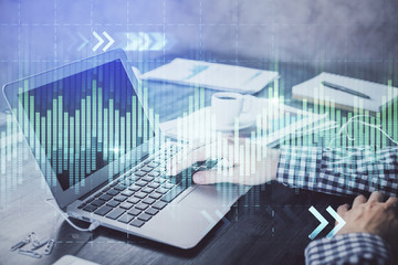 Double exposure of forex chart with man working on computer on background. Concept of market analysis.