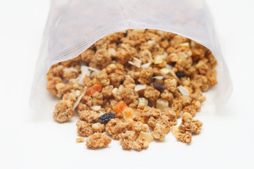 Granola with fruits and nuts in a transparent plastic bag. Baked muesli mix. Super food concept. Breakfast cereals. Kids diet. White isolation background.