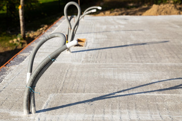 Empty conduits for power supply and controlled domestic ventilation on a concrete ceiling under construction