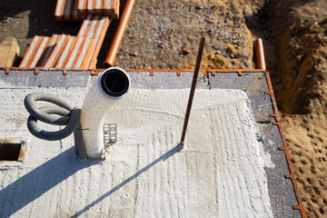 Empty conduits for power supply and controlled domestic ventilation on a concrete ceiling under construction