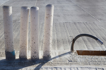 Empty conduits for power supply and controlled domestic ventilation on a concrete ceiling under construction