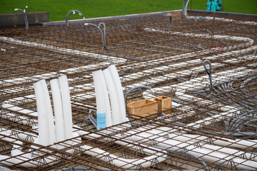 Empty conduits for power supply and controlled domestic ventilation on a concrete ceiling under construction