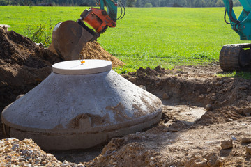 Concrete inspection manhole to access sewer is being installed on a construction site