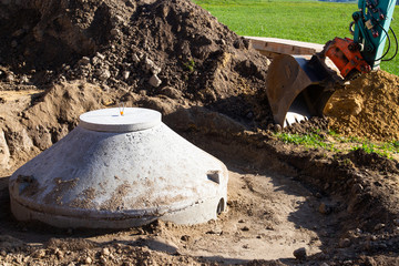 Concrete inspection manhole to access sewer is being installed on a construction site