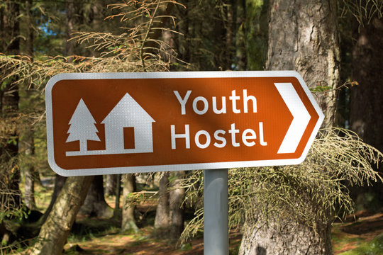 Youth Hostel sign in UK, with blurred forest background taken on sunny day at Rowardennan on West Highland Way