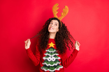 Photo of funny curly lady dreaming x-mas would bring peace and love to all people on earth looking empty space wear head horns pullover isolated red color background