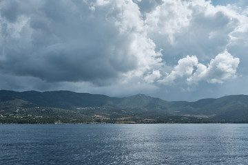 Seascape panorama from little boat in a cloudy day along the shoreline in sardinia.