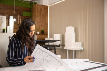 Young woman architect who controls the sketches of the real estate project