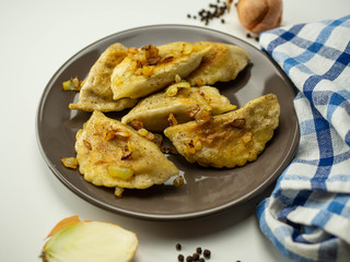 Pierogi z mięsem i smażoną cebulką. Zbliżenie.