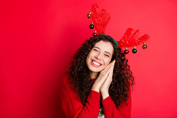 Portrait of cheerful funny funky brunette curly hair girl ready for christmas newyear party wait expect x-mas tradtion her gift present surprise wear trendy sweater isolated red color background