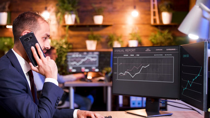 Businessman talking on the phone while working on the computer