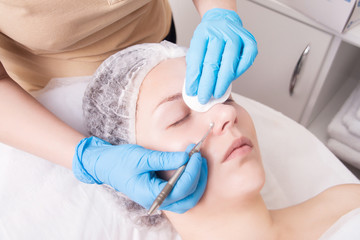Manual face cleansing from blackheads at a beautician in a beauty salon. Care for problem skin.