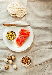 Salt Salmom with quail eggs, nuts, rice cakes and olive. Top view. Paleo diet. Healthy high protein and low carbohydrate products concept.