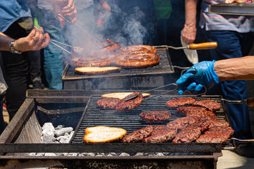 people cooking hamburgers on the barbecue